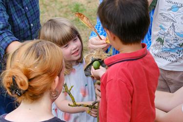 Children play with sticks and leaves.