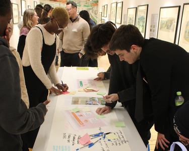 A group of young people collaborate around a table for a brainstorming session of the Youth Collective.